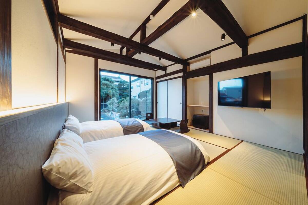 Un cuarto de hotel con una cama grande, televisión y vista al exterior.