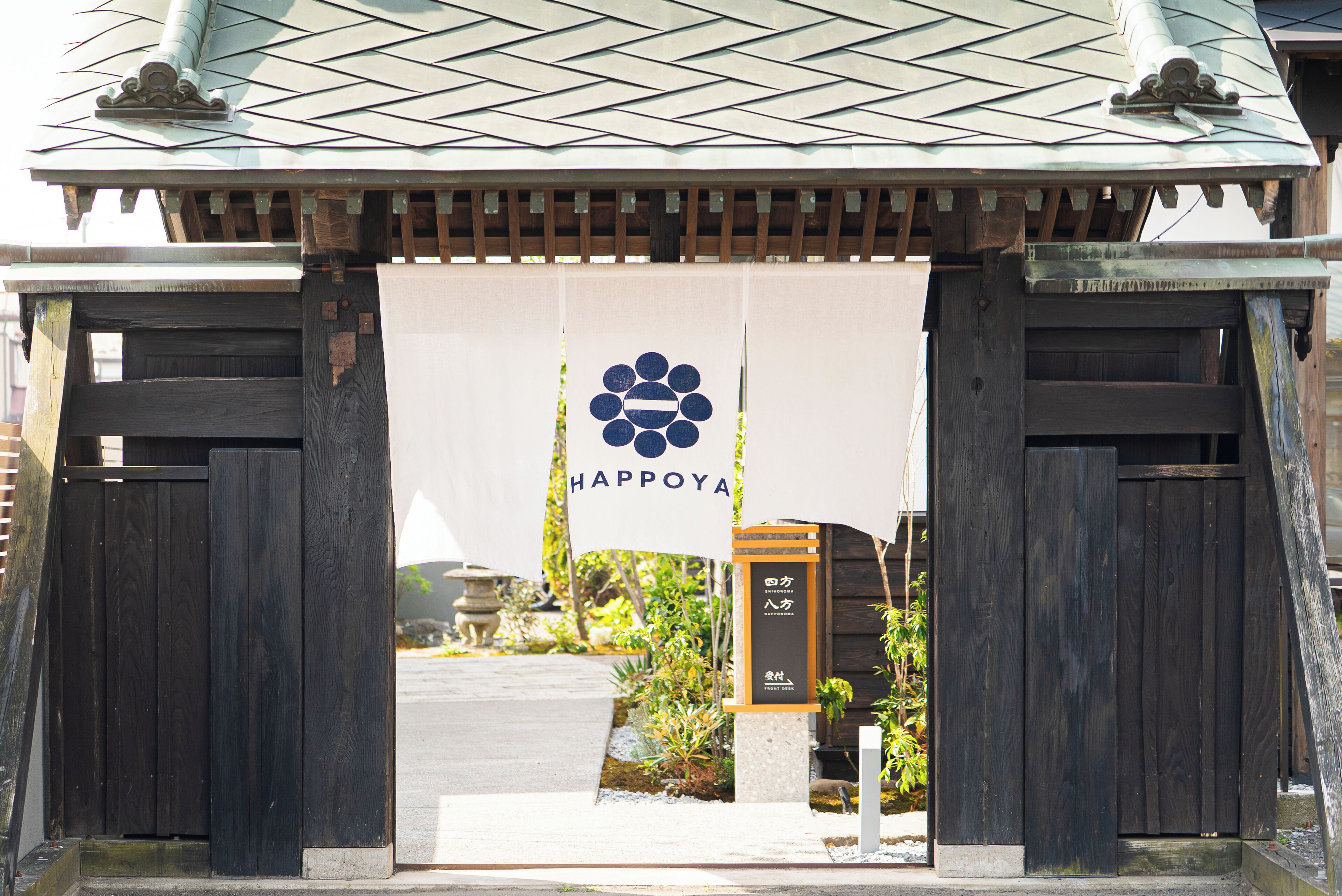 A wooden gate with a sign reading "Happoya" and a logo.