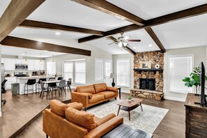 A spacious living area with a fireplace, a dining area, and a kitchen. - 3BR in Epic Central Area near AT&T Cowboy Stadium - Dallas (Grand Prairie)