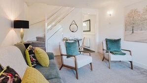 A modern living room with a staircase, a round table, and two armchairs. - Corner House - Bright 2BD in Cheltenham (Cheltenham)