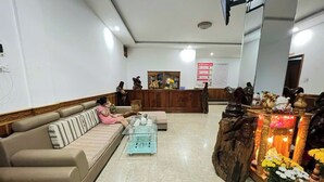 A lobby with a sofa, a reception desk, and a decorative altar.