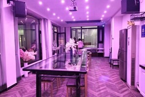 Une cuisine moderne avec une table à manger en verre, un plancher en bois et une vue dégagée grâce aux portes vitrées.