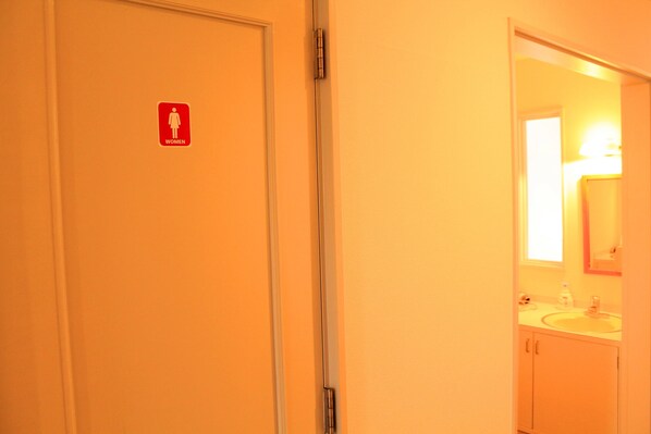 A women's restroom with a mirror and sink.