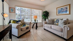 A living room with two sofas, a table, a lamp, a plant, and a painting on the wall. - Josiane's Chic Oasis (Davenport)
