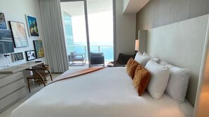 Una habitación de hotel moderna con una cama grande, un escritorio y vistas al océano.