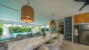 A modern kitchen with a marble countertop, wicker chairs, and pendant lighting. - 5 Star Villa with 5 Bedrooms, Bali Villa 2178 (Bali)