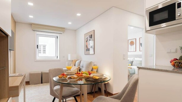 Une cuisine moderne avec une table à manger en verre, des chaises et un four à micro-ondes.