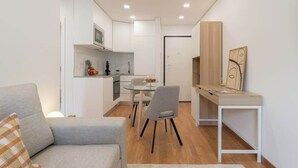 Un espace de vie compact comprenant un coin cuisine, un espace repas et un espace de travail.