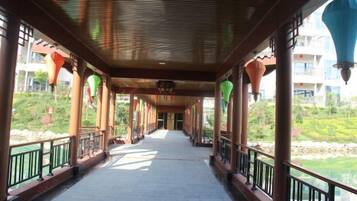 A covered walkway with columns and railings, leading to a building entrance.
