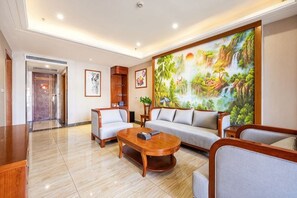 Un moderno vestíbulo de hotel con un cuadro grande, un sofá, una mesa de centro y una recepción.