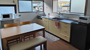 Eine kompakte Küche mit Essbereich, einer Mikrowelle, einem Spülbecken und einem Fenster mit Blick nach draußen.