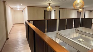 Una camera d'albergo moderna con una disposizione allungata e stretta, una reception in legno e due lampade a sospensione.