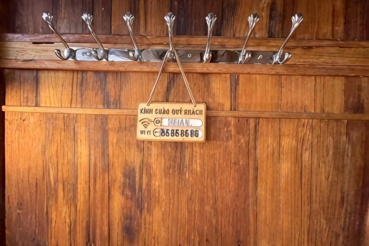 Un muro di legno con un cartello e degli ganci.
