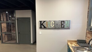 A kitchen area with a 'KITCHEN' sign, a wooden countertop, and a sink. - Livie’s Loft
Trendy loft on Main Street (Sardis)