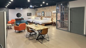 A modern room with two beds, a dining table, and orange chairs. - Livie’s Loft
Trendy loft on Main Street (Sardis)
