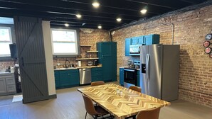 A modern kitchen with teal cabinets, stainless steel appliances, and a wooden dining table with two chairs. - Livie’s Loft
Trendy loft on Main Street (Sardis)