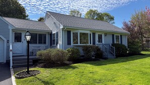 A two-story house with a front porch, a covered entryway, and a well-maintained lawn. - Orleans Beach Retreat (Orleans)