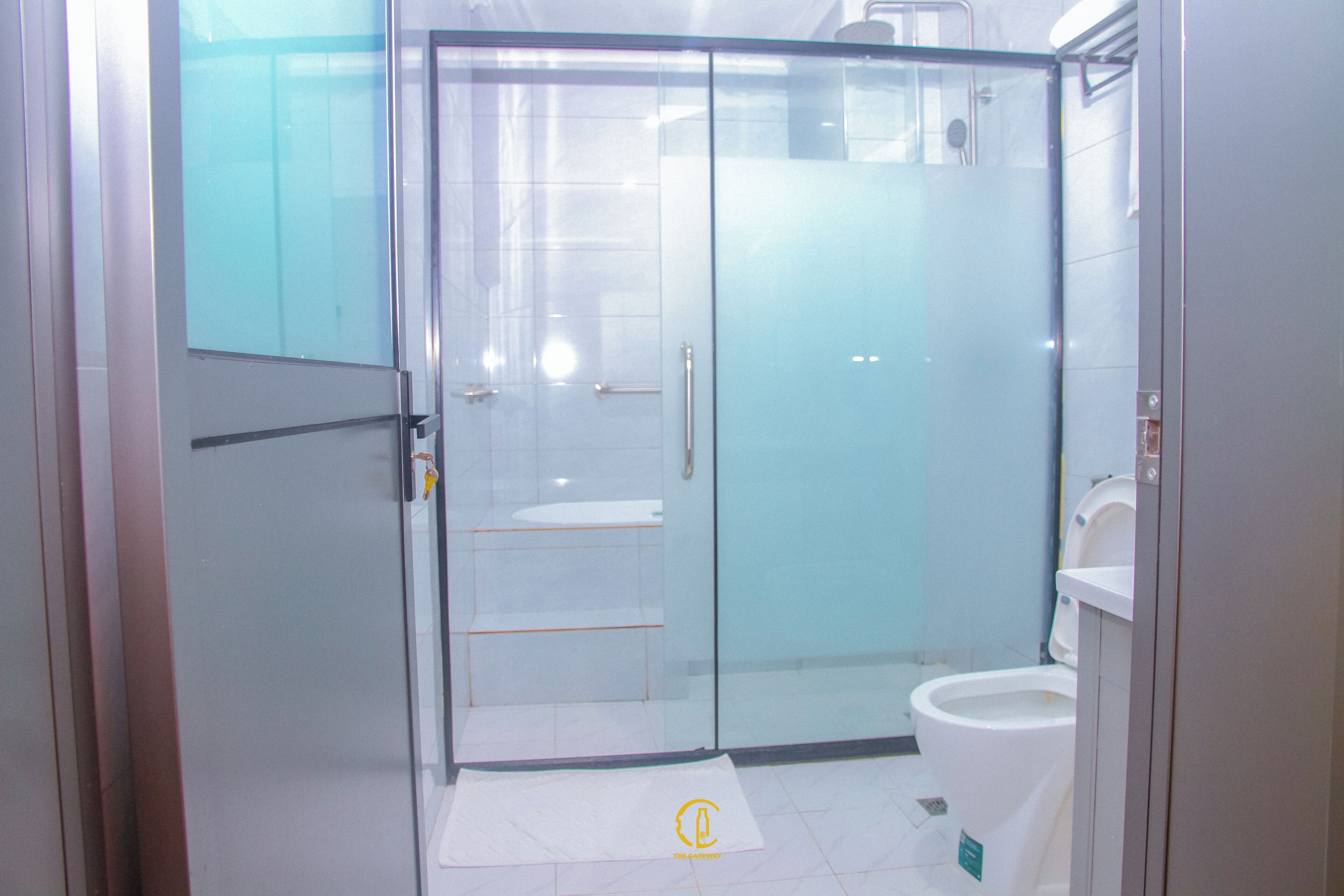Een moderne badkamer met een douchecabine van glas, een toilet en een wastafel.