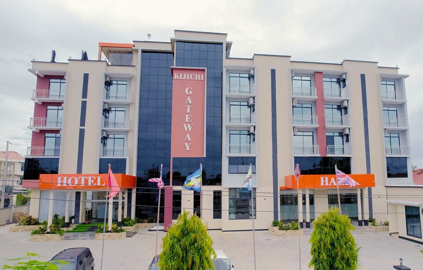 Un moderno edificio de hotel con varios pisos, balcones y un cartel llamativo del hotel.