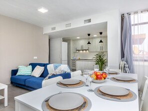 Relax in this stylish living space with a dining area, featuring a sofa, coffee table, and dining table set.