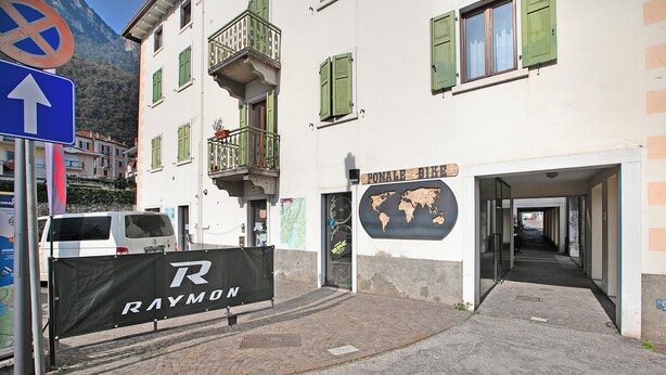 A building with a sign reading "RAYMON" and a map on the wall. - Ardaro 1 - Riva del Garda Apartment With 2 Balconies (Riva del Garda)