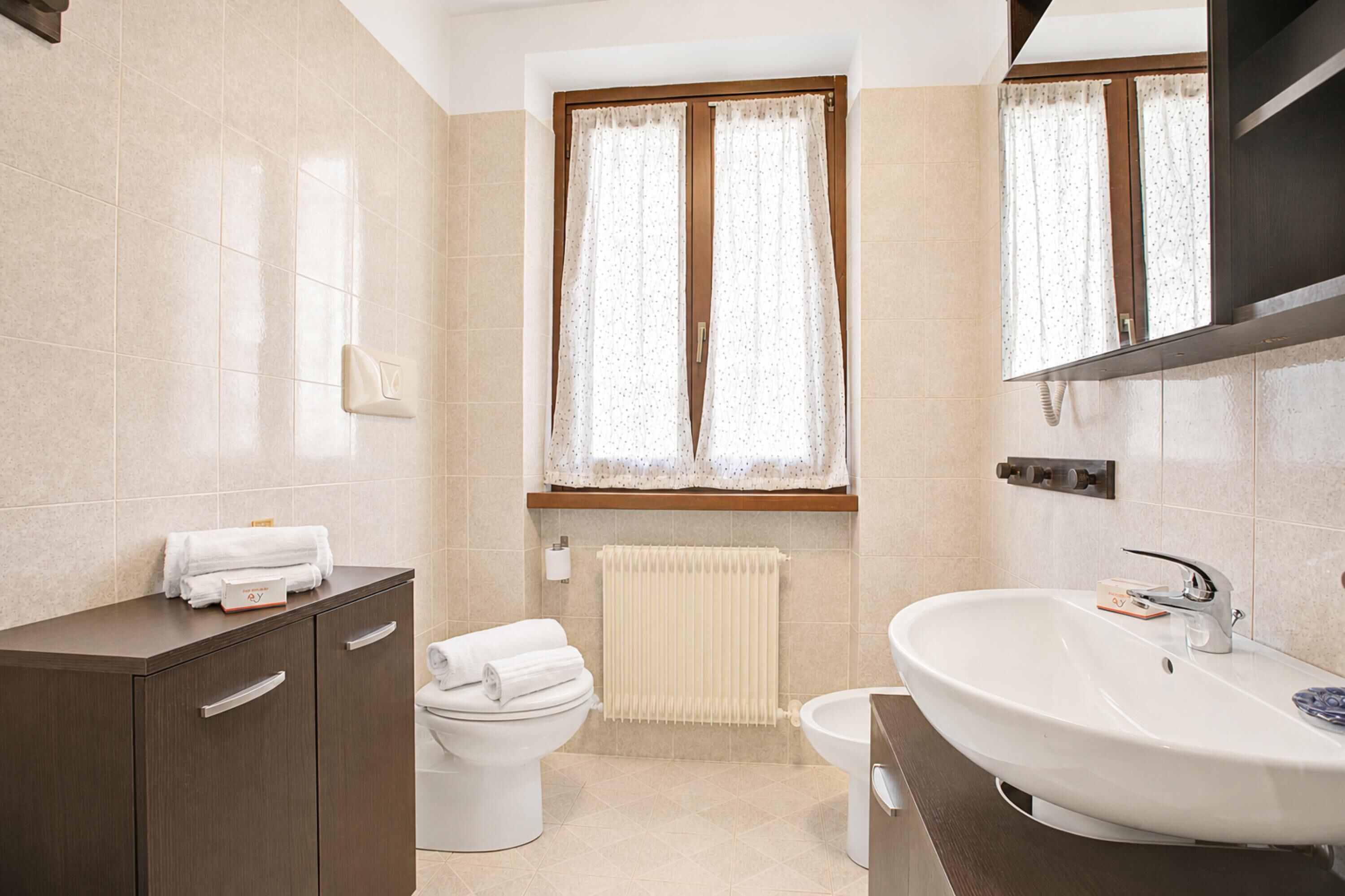 Ein Badezimmer mit Toilette, Waschbecken und Schrank.