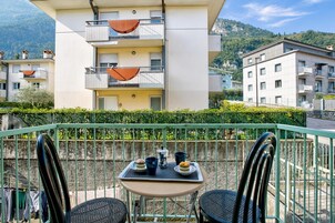 A balcony with two chairs, a table, and a tray with food and drinks.