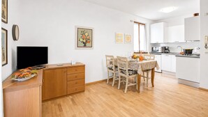 Ett kompakt bostadsutrymme med matplats, pentry och en platt-TV.