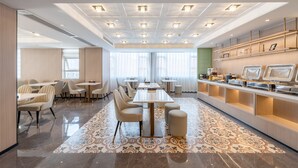 A modern hotel lobby with a long reception desk, seating area, and a buffet. - Huanyi Hotel  (Guangzhou)