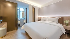A modern hotel room with a large bed, a desk, and a bathroom visible through an open door. - Huanyi Hotel  (Guangzhou)