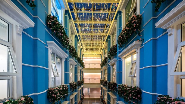 A grand hallway with blue walls, white trim, and a ceiling adorned with lights and decorations. - Huanyi Hotel  (Guangzhou)