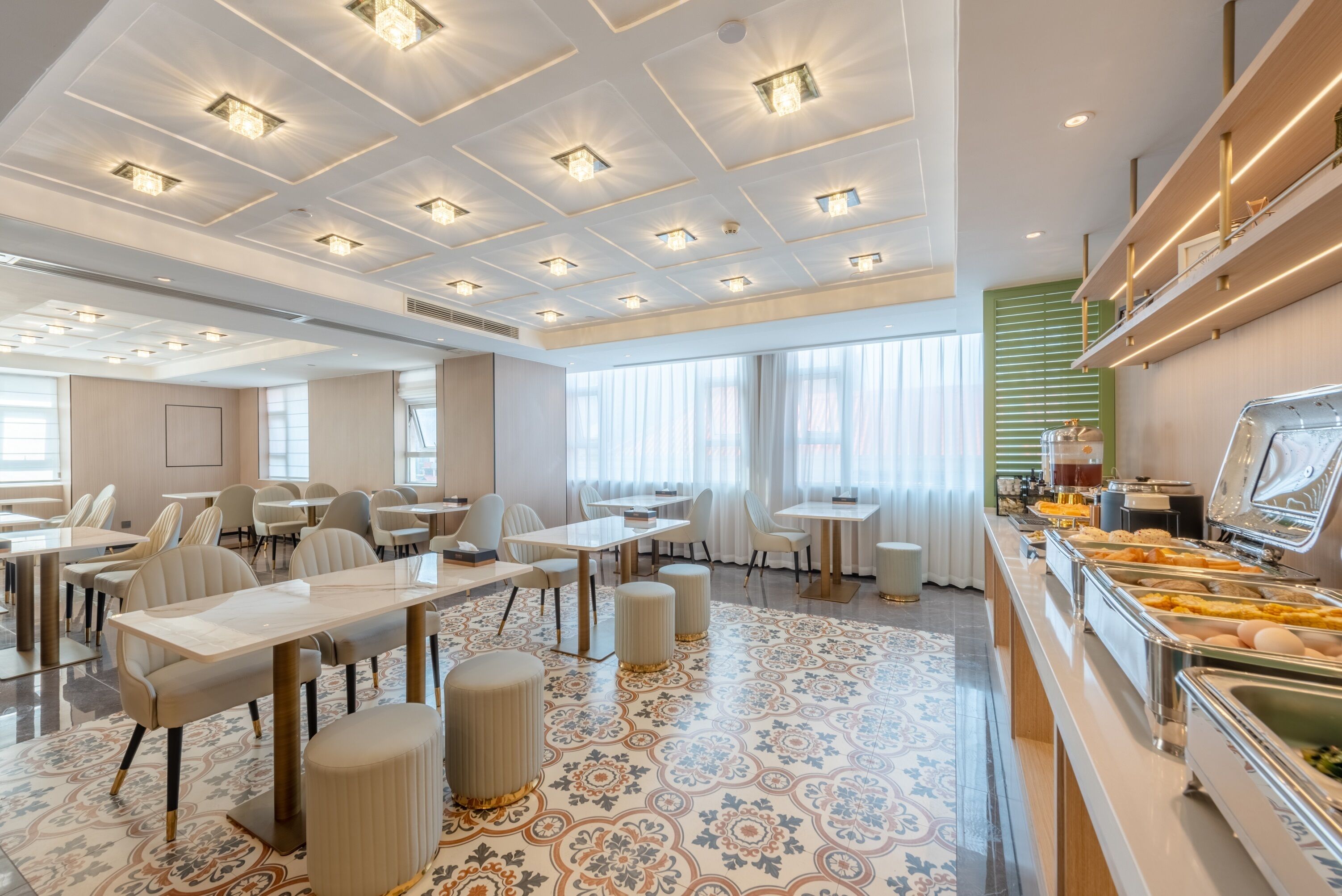 A hotel dining area with tables, chairs, and a buffet.