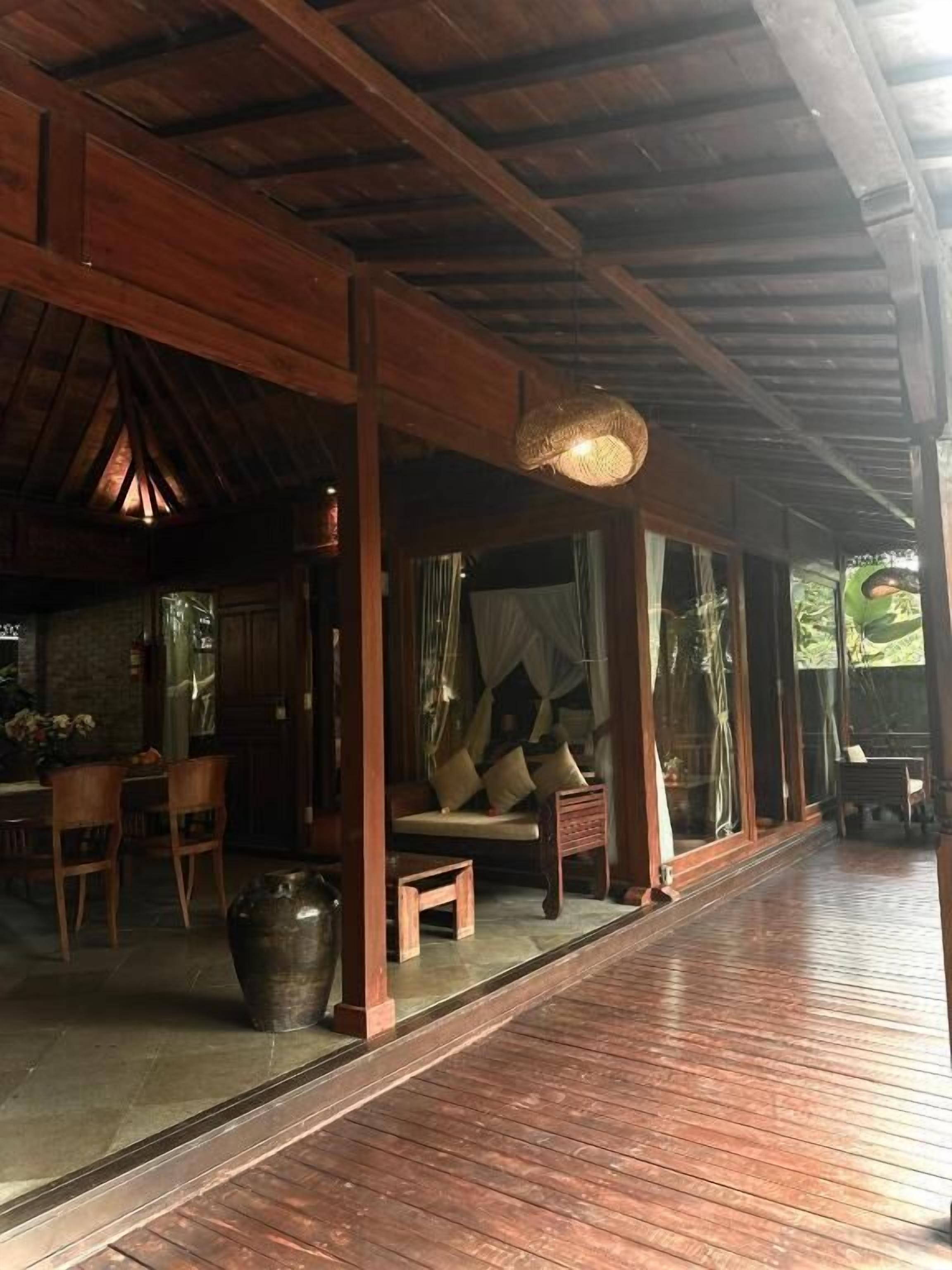 Un intérieur en bois comprenant un coin repas, un canapé et une grande fenêtre.