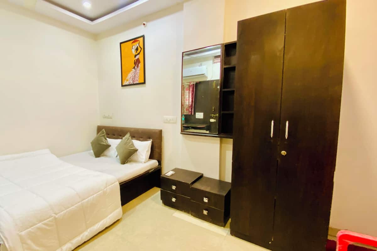 Ein Schlafzimmer mit Bett, Kleiderschrank, Nachttisch und einem wandmontierten Spiegel.