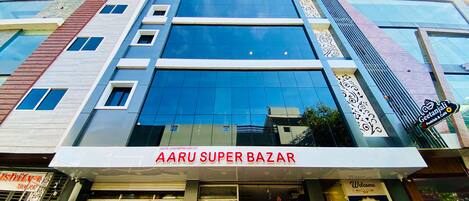 A multi-story building with a large glass facade and signage for 'AARU SUPER BAZAR'.