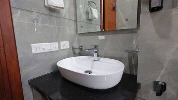 A bathroom with a white sink, a mirror, and a towel rack.