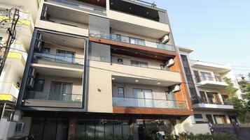 A multi-story building with balconies, air conditioning units, and a gated entrance.