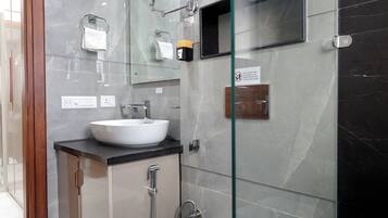 Une salle de bain moderne avec une douche à parois de verre, un lavabo blanc et des toilettes.