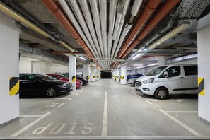 Park your car in our organized underground garage with designated parking spaces and clear directional arrows.