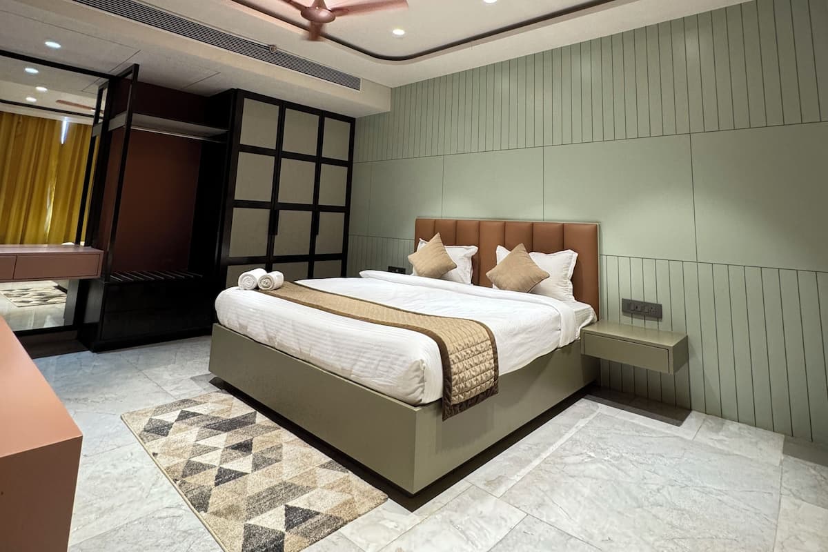 A modern bedroom with a large bed, bedside tables, a ceiling fan, and recessed lighting.