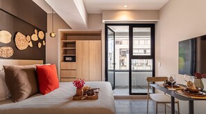 Relax in this stylish bedroom with a large bed, dining area, and city views.