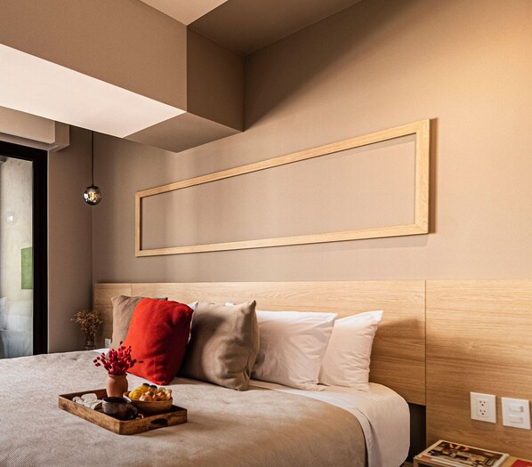 Cozy retreat with a neatly made bed, bedside table, and framed picture.