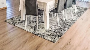 Ein moderner Essbereich mit einem rechteckigen Tisch, sechs Stühlen und einer dekorativen Mittelstück.