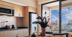 Enjoy a city view from the large window in this apartment's spacious kitchen, complemented by a cozy seating area.