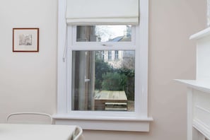 A room with a white window, a framed picture on the wall, and a white chair. - Traditional Bath House, Garden with City Views (Bath and North East Somerset)