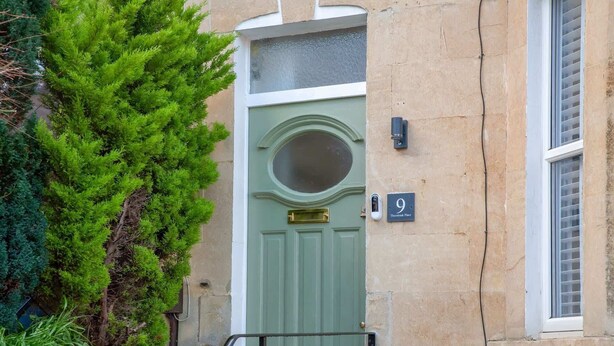 A green door with a round window above it, a house number '9', and a small mailbox to the left. - Traditional Bath House, Garden with City Views (Bath and North East Somerset)
