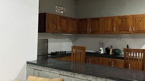 Una cocina moderna con armarios de madera, encimera de granito y horno empotrado.