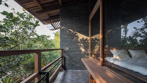 A bedroom with a large window, a wooden bench, and a balcony with a railing. - Hachi Homestay & Spa (Hue)