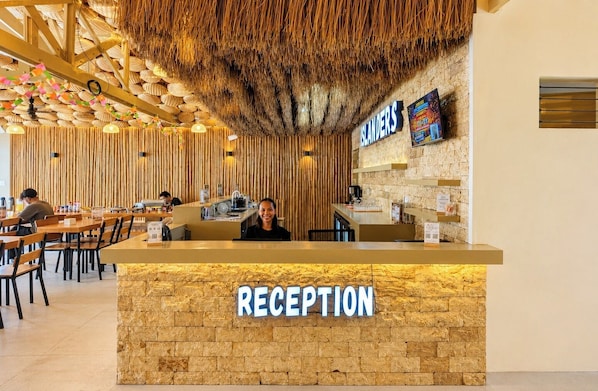 Un área de recepción con un mostrador de madera, un letrero que dice 'RECEPTION' y un cartel con la palabra 'SLANDERS' arriba.
