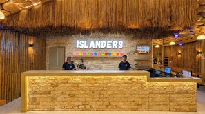 A reception area with a stone counter, a sign reading 'ISLANDERS', and a menu board.